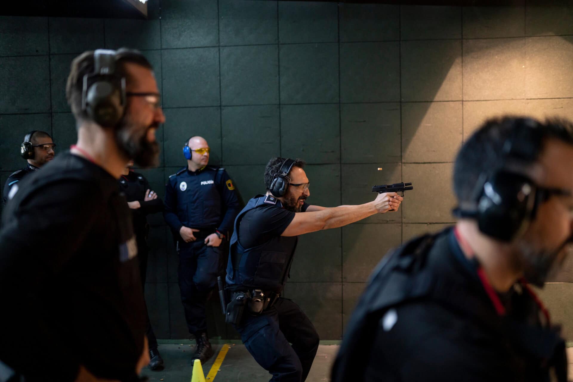 Police training in shooting gallery with short weapon.